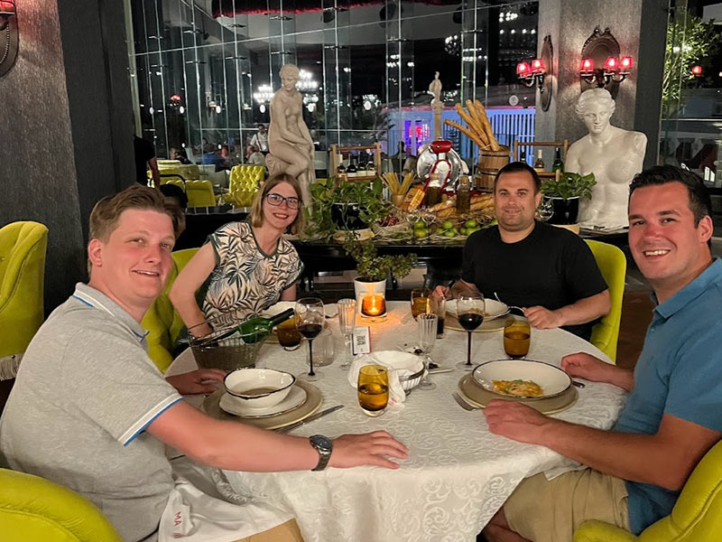 Vier collega’s eten samen in een restaurant tijdens een teamreis.